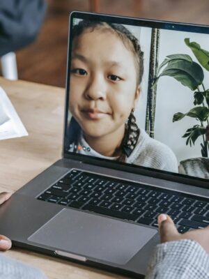 A teacher holding an online class with diverse students through a laptop during a distance learning session.